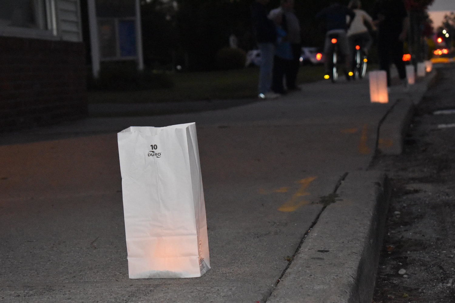Luminaries on Blue Point Avenue. Just before dusk, volunteers set luminaries on sidewalks along the street. Mollie Dombrowsky, a 10-year-old who was working alongside her mother, Kristen, said during the vigil she would be thinking “about how Gabby is watching down on them from heaven.”